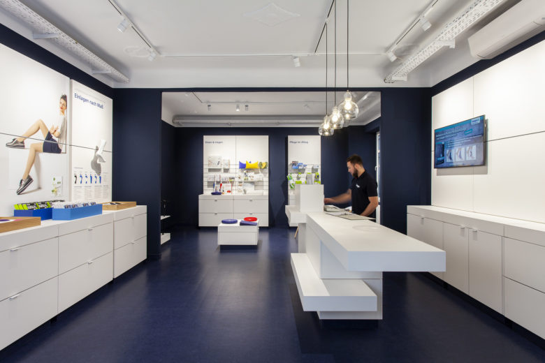 SEEGER醫療用品商店空間設計，地板墻壁的深藍色與純白色家具形成鮮明對比